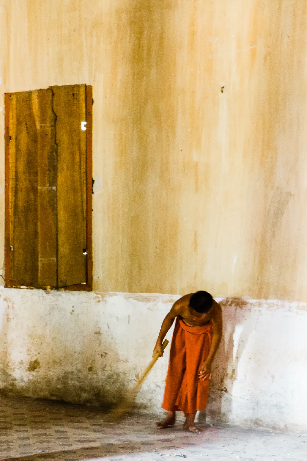 Monk with a broom #2. Wat Samrong Knong, Battambang, Cambodia. February 2014