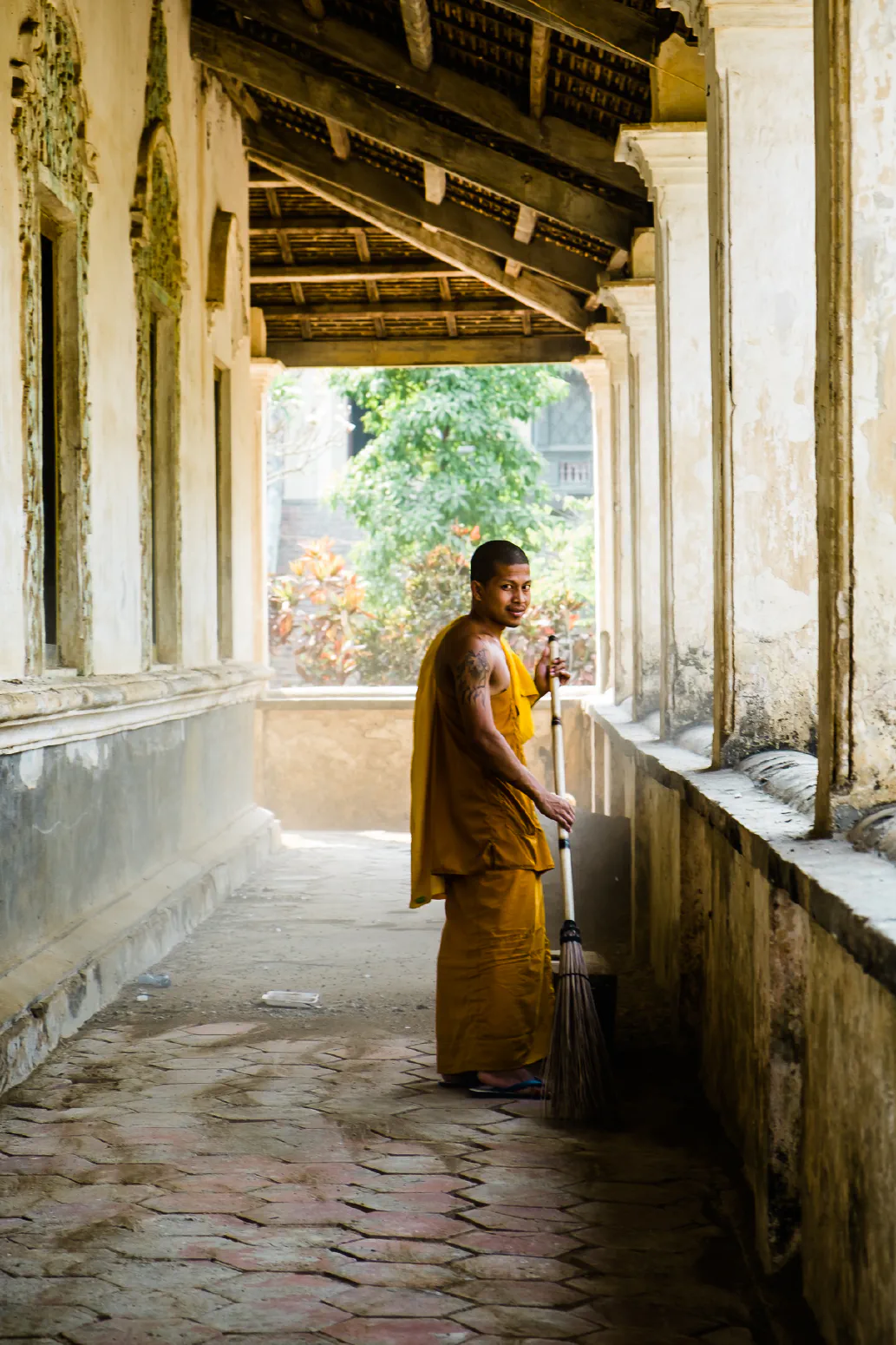Monk with a broom #1. Wat Samrong Knong bei Battambang, Cambodia. Februar 2014